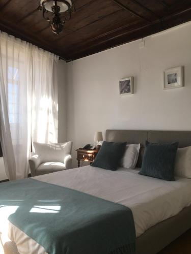 纳扎雷里巴马酒店的卧室配有床、椅子和窗户。