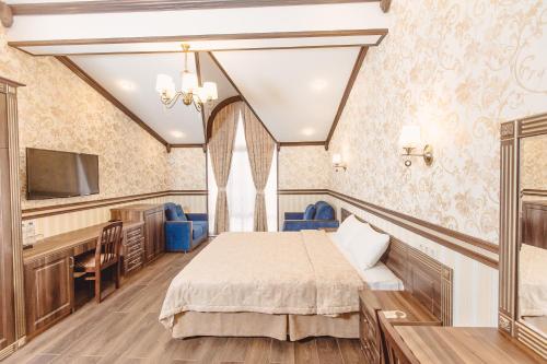 索契Villa Polianna的一间卧室配有一张床、一张书桌和一台电视。