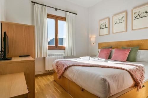 上阿兰Luderna - Apartamento Tanau A1 Esquirós的一间卧室设有一张大床和一个窗户。
