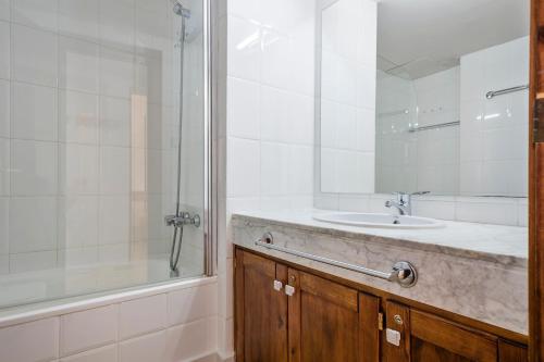 上阿兰Luderna - Apartamento Tanau A1 Esquirós的一间带水槽、淋浴和镜子的浴室