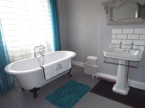 科尔福德欧德维卡里奇住宿加早餐旅馆的浴室配有白色浴缸和水槽
