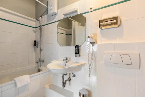 科隆A&O科隆火车总站酒店 的白色的浴室设有水槽和卫生间。