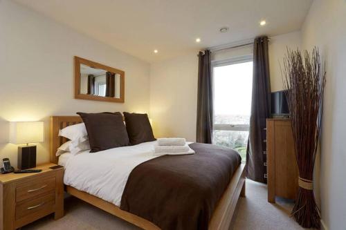 斯劳MODERN APARTMENT at SLOUGH STATION, LONDON IN 18 MINS!的一间卧室设有一张大床和一个窗户。