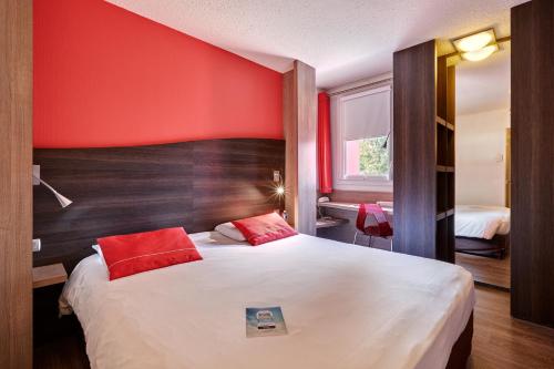 永河畔拉罗什基里亚德罗驰苏尔永酒店的一间卧室设有一张红色墙壁的大床