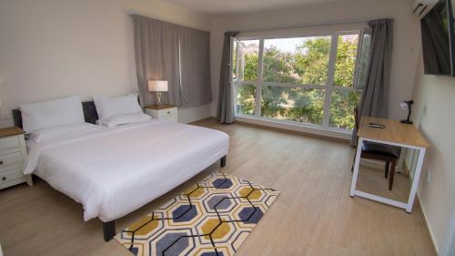 弗里敦新布鲁克菲尔兹酒店的一间卧室配有一张床、一张书桌和一个窗户。