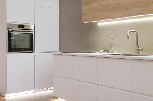布尔诺New luxury main square apartment的白色的厨房配有水槽和微波炉