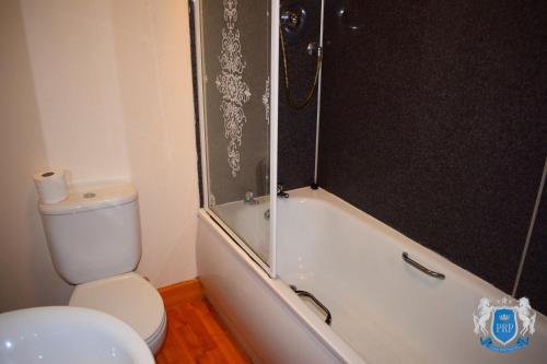 埃尔金Two Bedroom Town Centre Apartment的浴室配有卫生间、淋浴和浴缸。