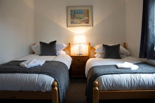诺里奇Wensum Cottage的带灯的客房内的两张单人床