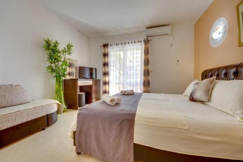 乌尔齐尼普里玛菲拉别墅公寓酒店的一间卧室配有一张大床和一张沙发