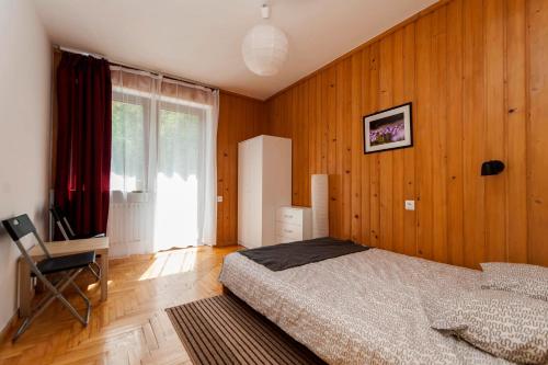 克雷尼察Krynica Zamkowa 48的卧室设有木墙、一张床和窗户