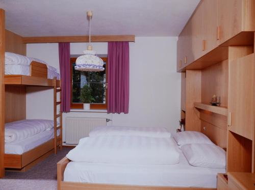 瓦尔奥纳的圣乔凡尼Appartement Wasserer的一间卧室设有两张双层床和一扇窗户。