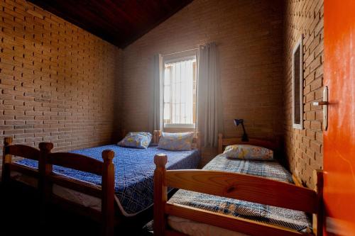 乌巴图巴Casa c/ churrasqueira próximo à praia em Ubatuba的一间卧室设有两张床和窗户。