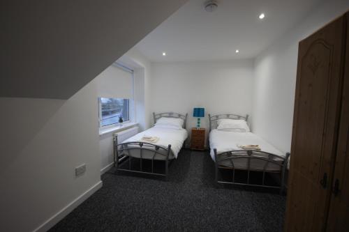 德里门Loch Lomond Riverside Apartment的客房设有两张床和窗户。