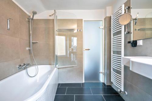 汉诺威威甘德设计酒店的带淋浴、浴缸和盥洗盆的浴室