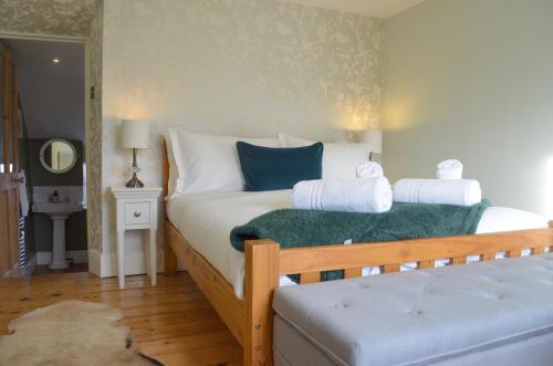 水上伯顿Darly Cottage的一间卧室配有带白色床单和蓝色枕头的床。