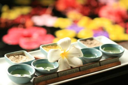 科罗尔帕劳太平洋度假酒店的盘子上放着几个碗和一朵花