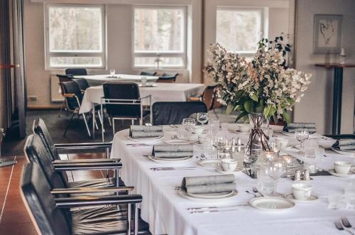 KiljavaHotel Kiljava的用餐室配有白色的桌椅和鲜花