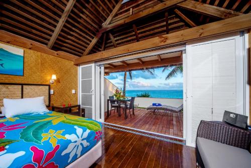 拉罗汤加棕榈树林酒店的一间卧室配有一张床,享有海景