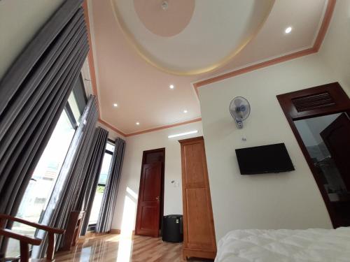 保禄Khách sạn Nguyên Long的卧室配有一张床,墙上配有电视。