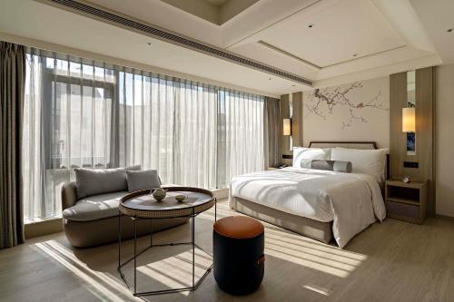 台北瀚寓酒店的一间卧室配有一张床、一张沙发和一张桌子