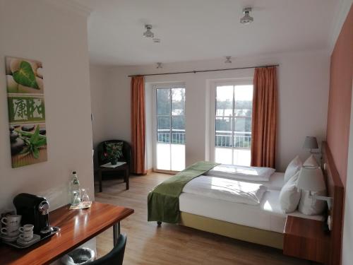 马尔肖Hotel Villa Passion的卧室配有一张床、一张书桌和窗户。