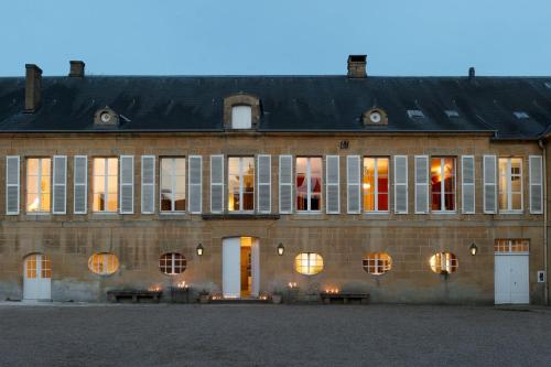 Château de Martigny的一座带窗户和黑色屋顶的大型砖砌建筑