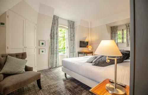 若博瑟滨海地区酒店的一间卧室配有一张床、一把椅子和一盏灯