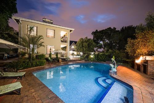 约翰内斯堡Gallo Manor Executive Bed & Breakfast的房屋前的大型游泳池