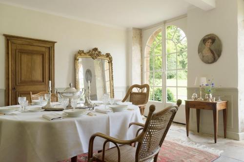 Château de Martigny的一间带桌子和镜子的用餐室