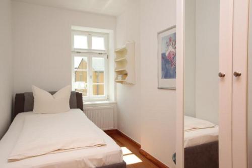 欧巴德伍斯图Gästehaus Schimmel´s的一间卧室设有一张床、一个窗口和一面镜子