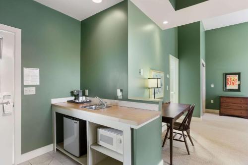 曼切斯特The Palmer House Resort, Ascend Hotel Collection的厨房设有绿色的墙壁、水槽和桌子