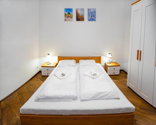 乌斯特龙Apartament Pod Czantorią - Nowoczesny apartament z widokiem na Czantorię的一间卧室配有一张带2个床头柜和2盏灯的床。