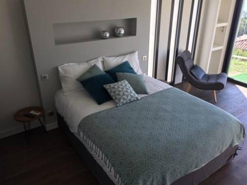 巴斯蒂亚Maison d'hôtes Bastia的一间卧室配有一张带蓝色和白色枕头的床