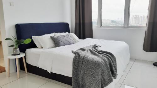 普崇No.11 The John @ Puchong Skypod Residence的卧室内的一张带白色床单和枕头的床