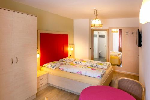 奥蒂塞伊Apartments Diamant的一间卧室配有一张红色床头板的床