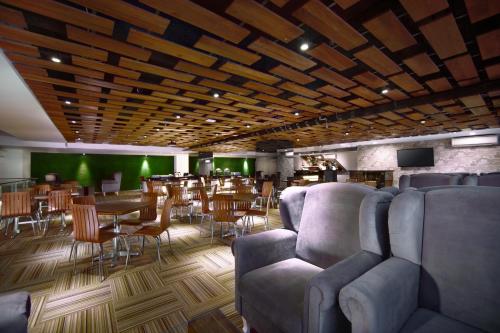 泗水泗水发富格拉古酒店的一间带沙发和桌子的餐厅和一间酒吧
