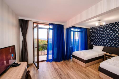 MiladinowziПиргуля的一间卧室配有床和蓝色窗帘的窗户