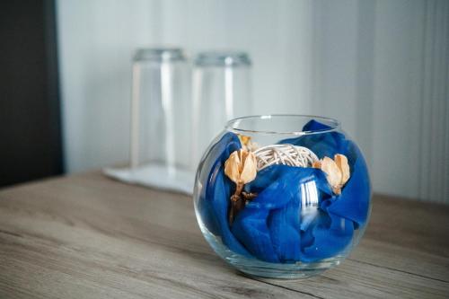 MiladinowziПиргуля的一张蓝色玻璃花瓶,坐在木桌旁