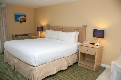 法尔茅斯InnSeason Resorts Surfside的卧室配有一张白色的大床和电话