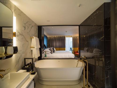 伦敦The Guardsman - Preferred Hotels and Resorts的带浴缸和床的浴室