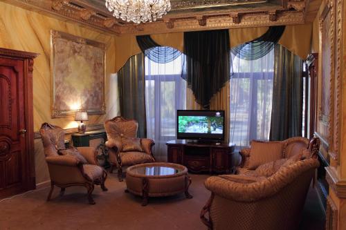 久姆里埃里桑德拉珀尔宫酒店的客厅配有椅子、电视和桌子