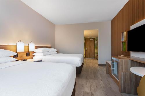 奥兰多Wyndham Garden Orlando Universal / I Drive的酒店客房设有两张床和一台平面电视。