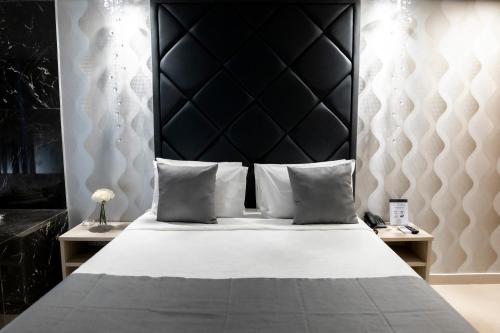 巴西利亚Cancún Hotel by H Hotéis - Airport的一间卧室配有一张大床和黑色床头板