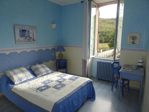 La Salvetat-PeyralèsAuberg'IN !的蓝色的卧室设有床和窗户
