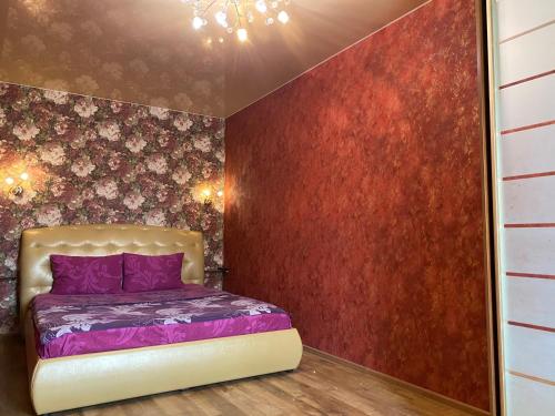 哈尔科夫New apartments with panoramic views on Avenue Nauky的一间卧室设有紫色的床和红色的墙壁