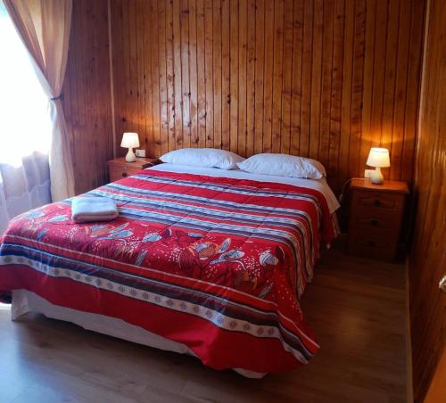 安东尼奥港Turismo Don Hugo的一间卧室配有一张带红色和蓝色毯子的床