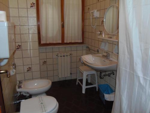 莫内利亚意大利酒店的浴室设有2个水槽、卫生间和镜子。
