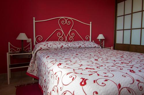 阿尔巴拉辛巴莱纳公寓的红色卧室配有一张带白色床罩的大床