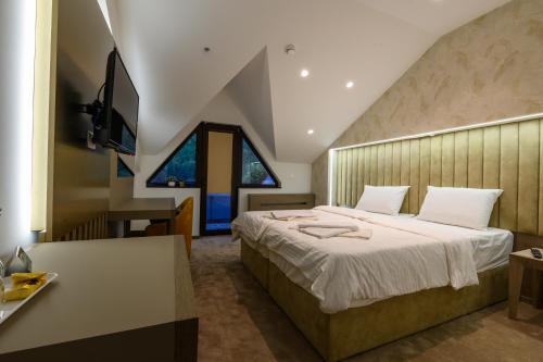 科查尼Euro Hotel Gradche的一间卧室配有一张大床和一张书桌
