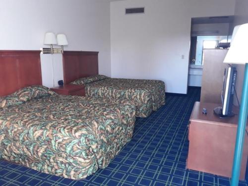 苏华德日落套房酒店的酒店客房设有两张床和一台平面电视。
